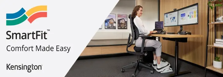 Das Bild zeigt eine Frau an einem ergonomisch eingerichteten Arbeitsplatz mit dem Kensington SmartFit-System. Sie sitzt auf einem Bürostuhl, während sie an einem höhenverstellbaren Schreibtisch mit zwei Monitoren arbeitet. Eine ergonomische Fußstütze und eine korrekte Sitzhaltung betonen den Komfort und die Anpassungsfähigkeit des SmartFit-Systems.