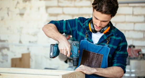 Ein Mann bohrt in ein Brett.