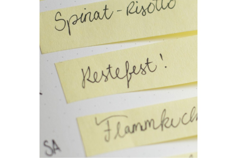 Nahaufnahme eines Wochenplans mit Eintrag „Restefest!“ auf Post-it