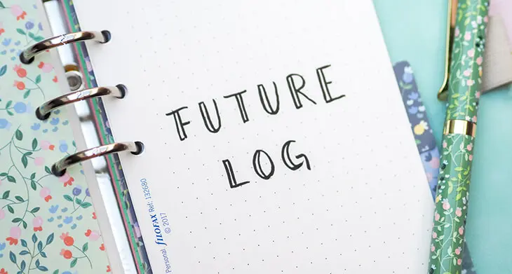 In einem aufgeschlagenen Filofax Planner steht auf einer Seite in großen Druckbuchstaben „future log“. Daneben liegt ein grüner Kugelschreiber mit bunten Blümchen. Foto: Johanna Rundel)