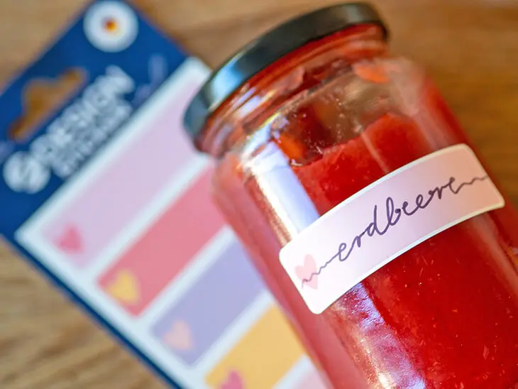 Ein Glas Erdbeermarmelade mit Herzaufkleber von Avery Zweckform liegt auf Klebeetiketten. Foto: Johanna Rundel