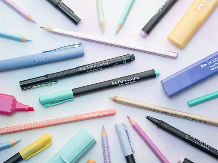 Stifte von Faber-Castell liegen verstreut auf einem bunten Untergrund. Foto: Johanna Rundel