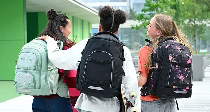 Drei Jugendliche mit verschiedenen Schulrucksäcken von coocazoo auf dem Rücken.