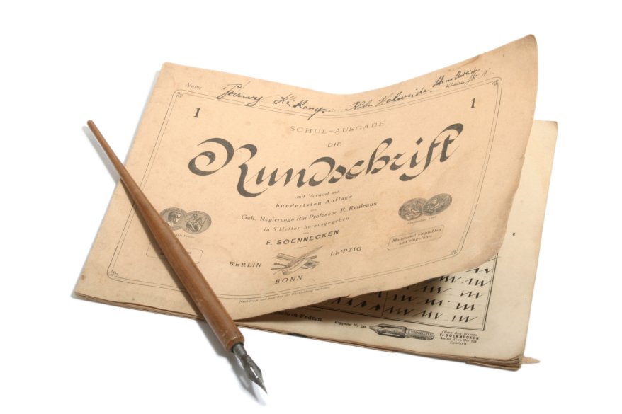 Ein altes Heft mit der Rundschrift von Friedrich Soennecken und einer alten Feder.