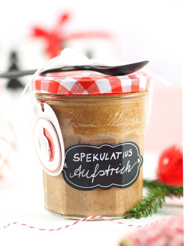 Ein Marmeladengals gefüllt mit selbstgemachter Spekulatiuscreme ist verziert mit einem beschrifteten Tafel-Etikett der Marke Herma.