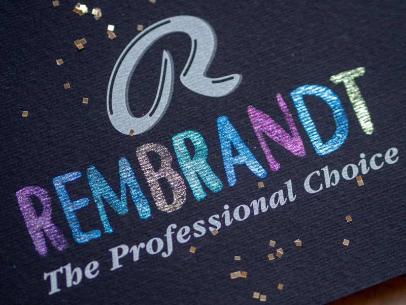 Schwarzes Aquarellpapier mit glittzerndem Schriftzug "Rembrandt"
