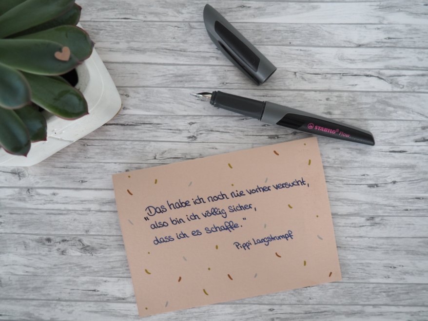 Draufsicht auf eine Karte mit einem Spruch zum Abschluss, daneben Füller Active Flow.