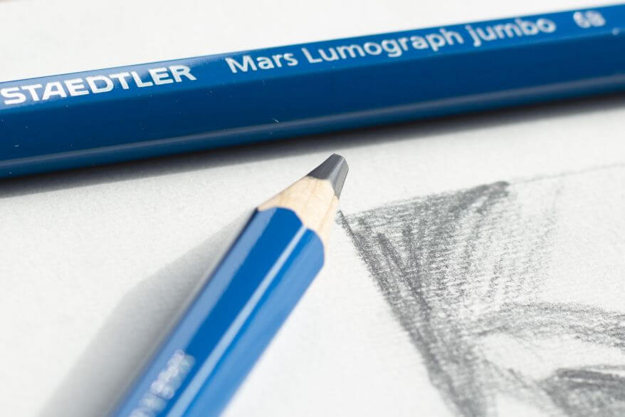 Nahaufnahme eines Graphitstifts Jumbo der Marke Staedtler. Zu sehen ist eine dunkel schraffierte Zeichnung im Anschnitt.