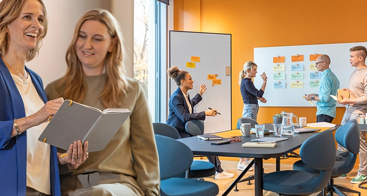 Menschen arbeiten mit SIGEL Notizbuch und Whiteboard in modernem Büro.