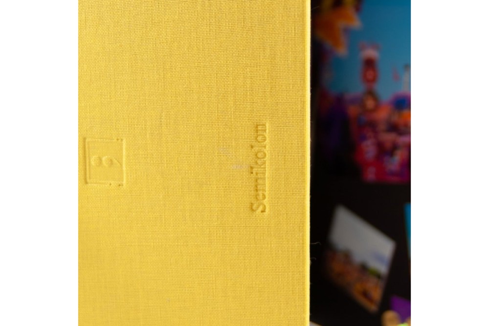 Nahaufnahme eines gelben Foto-Albums mit Semikolon-Prägung.