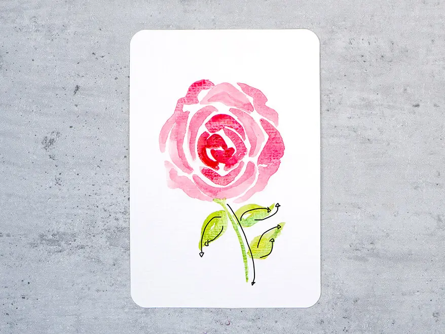 Auf eine Aquarellpostkarte von Hahnemühle wird Schritt für Schritt eine rote Rose aquarelliert. Hier ist Schritt sieben zu sehen: Blütenstiel und Blätter.