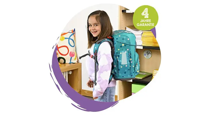 Ein Mädchen mit einem Schulranzen von Step by Step auf dem Rücken lächelt in die Kamera