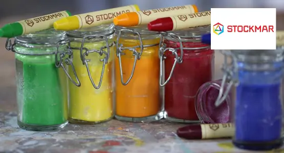 Nahaufnahme von 5 Weckgläsern mit je einer Farbe darin, darauf liegen Wachsmalstifte von STOCKMAR. Rechts oben ist das Logo von STOCKMAR abgebildet.