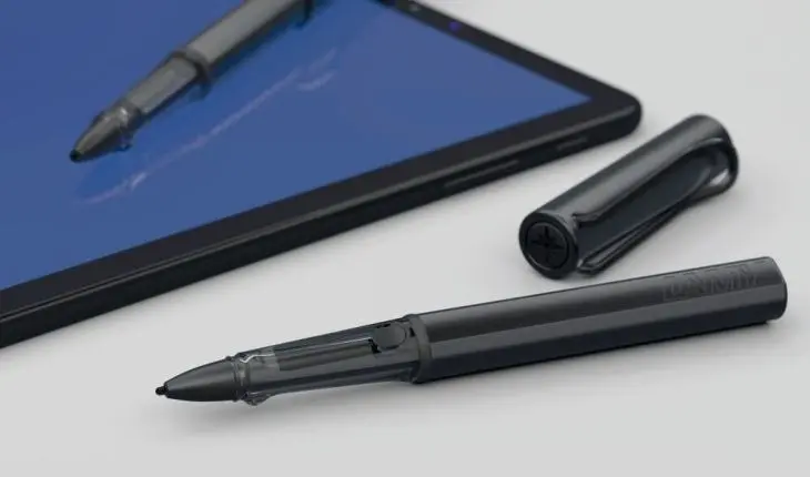 Ein schwarzer Lamy Al-Star Black EMR liegt geöffnet auf einem Tisch. Ein weiterer Lamy Al-Star Black EMR liegt auf einem Tablet.