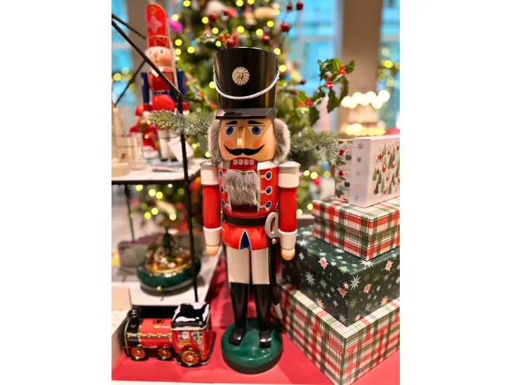 Weihnachtsdekor und ein großer Nussknacker vor einem Weihnachtsbaum.