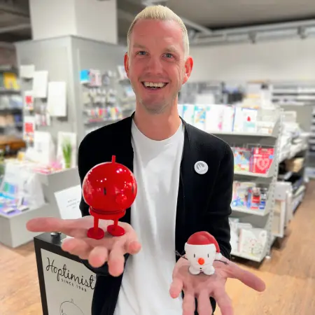 Ein Mitarbeiter von Ortloff hält zwei Hoptimisten in der Hand und lächelt in die Kamera.