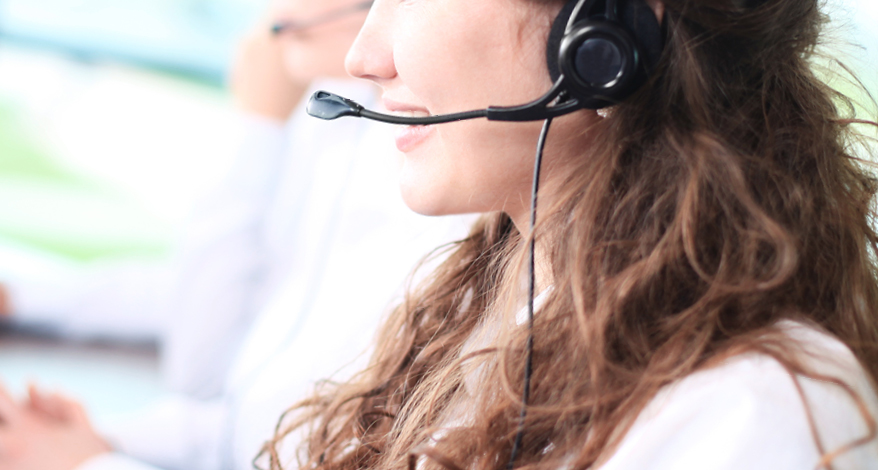 Nahaufnahme einer Frau, die mit einem Headset telefoniert.