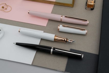 3 Schreibgeräte der Linie design06 in rosa, weiß und schwarz von Otto Hutt liegen auf dem Tisch.