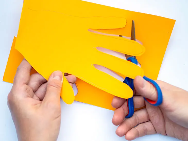 Jemand schneidet mit einer Kinderschere von STAEDTLER den Bleistiftumriss einer Hand aus. Foto: Johanna Rundell