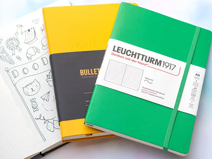 Mehrere Bullet Journals und Notizbücher von LEUCHTTURM1917 liegen aufgereiht nebeneinander. Foto: Johanna Rundel