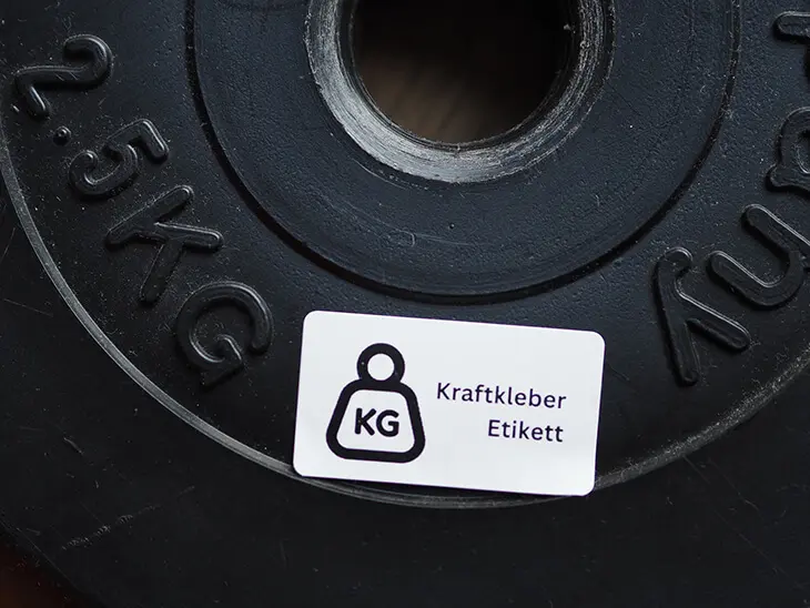 Ein Kraftkleber-Etikett von Avery Zweckform haftet auf einem 2,5kg Gewichtsring. Foto: Johanna Rundel