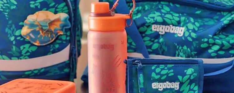 Nahaufnahmen Trinkflasche und Brustbeutel von ergobag vor Schulranzen.