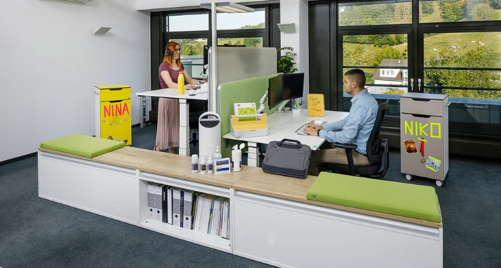 Zwei Personen sitzen an Ihren ergonomischen Schreibtischen.