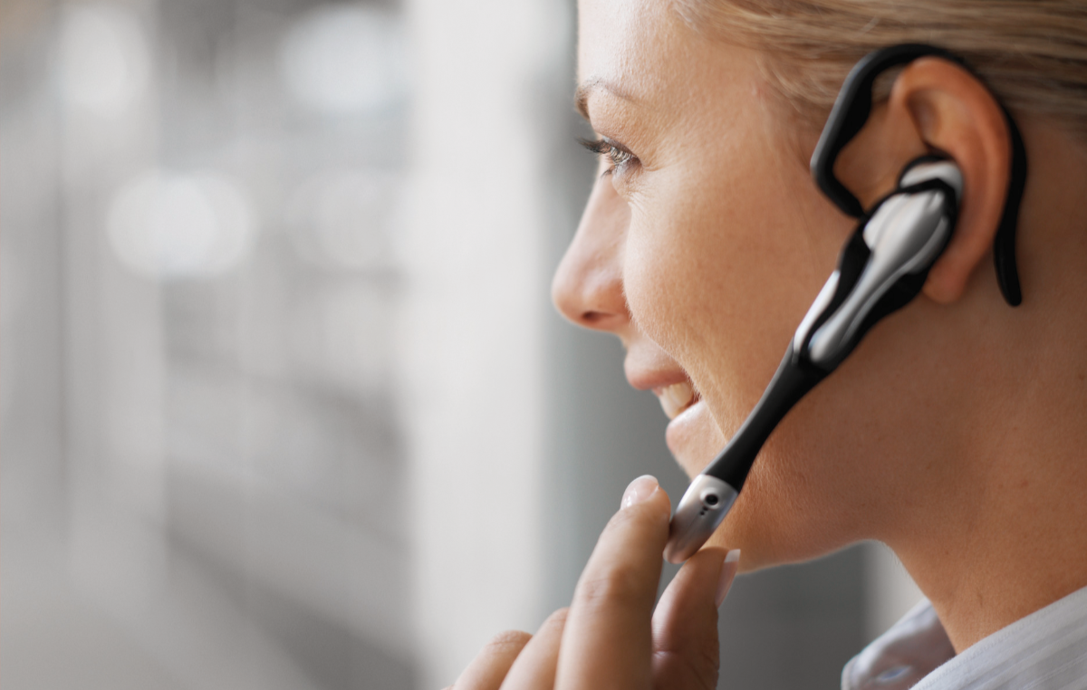 Nahaufnahme einer Frau, die mit einem Headset telefoniert.