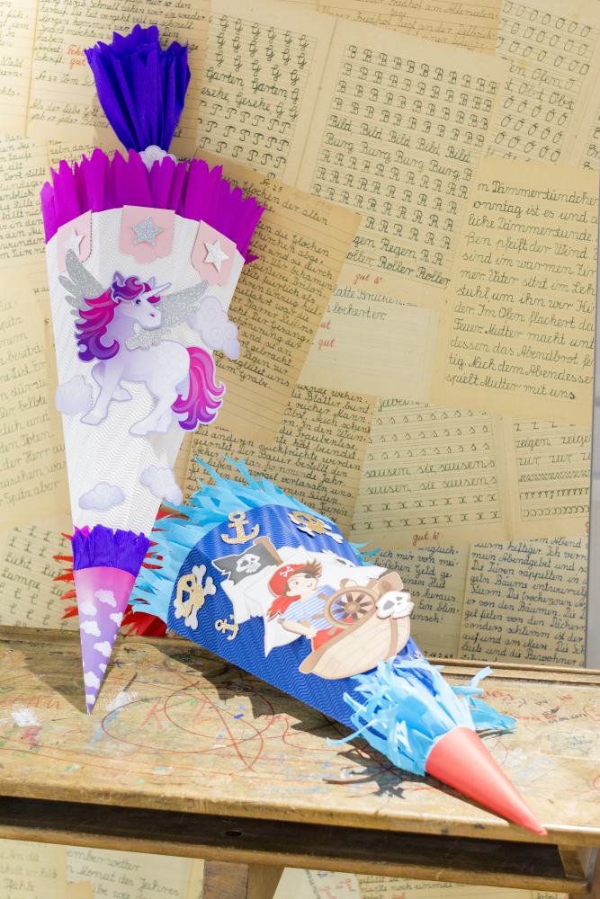 2 fertig gebastelte Schltüten aus den Bastel-Sets von Heyda mit Piraten- und Einhorn-Motiv.