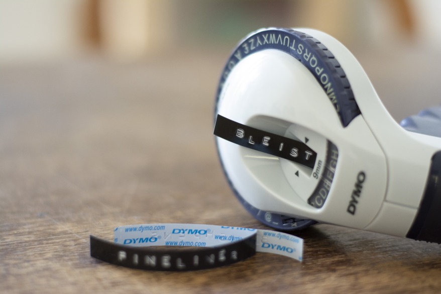 Beschriftungsgerät von Dymo mit geprägtem Schriftband, auf dem "Fineliner" steht."