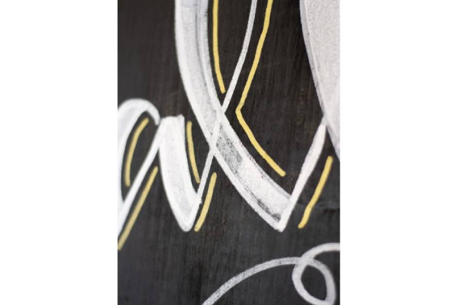 Nahaufnahme: Kreideschrift auf schwarzer Tafel mit sichtbarer Textur