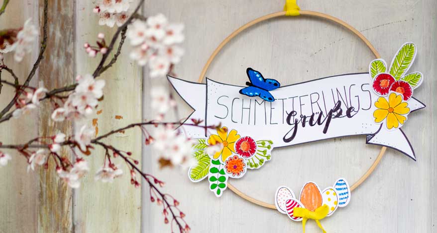 Selbstgebastelter Dekoreif an Tür mit Aufschrift „Schmetterlingsgrüße“