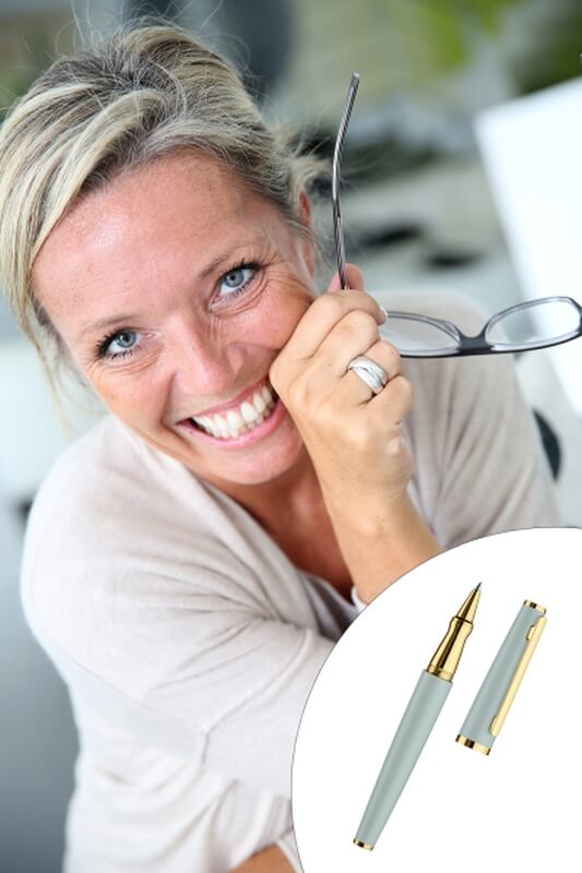 Eine Frau lacht in die Kamera. Rechts unten im Bild ist ein Kugelschreiber design06 von Otto Hutt abgebildet. 