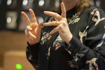 Nahaufnahme von Händen, die Lockerungsübungen machen: gespreizte Finger, Handgelenke drehen sich.