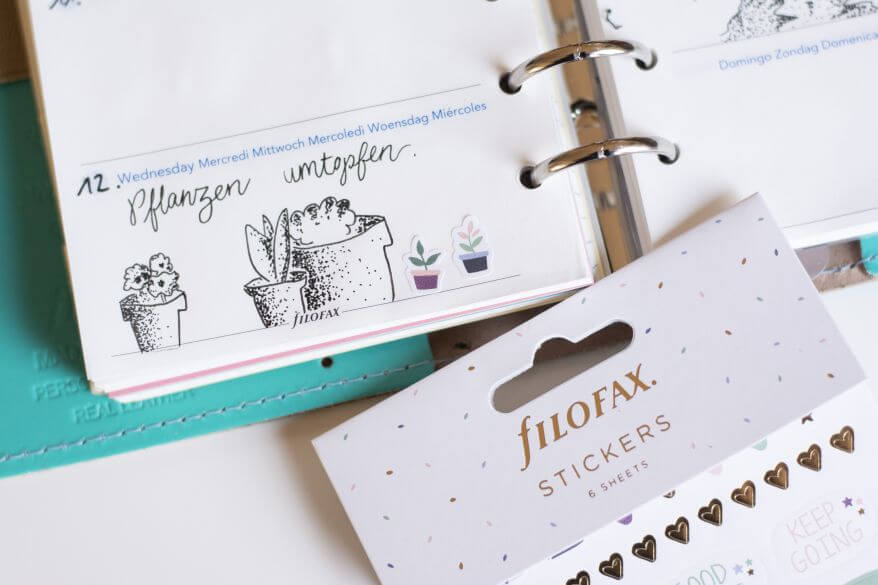 Nahaufnahme von einem aufgeschlagenen Kalender und Stickerbogen von Filofax.