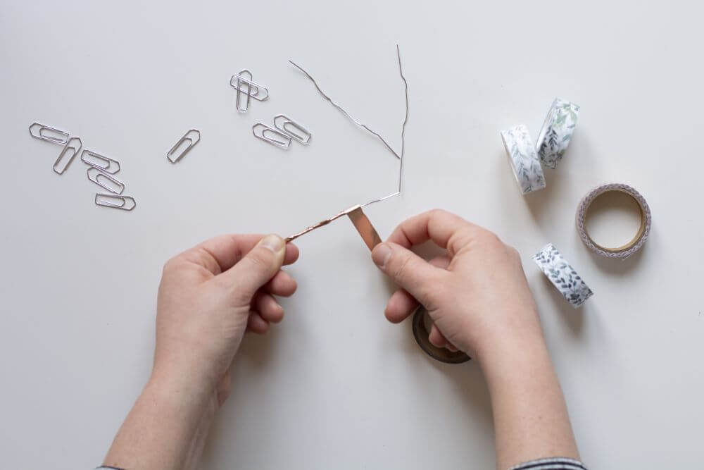 Bastelanleitung Do it yourself-Papierfedern. Schritt 3: Büroklammer aufbiegen und mit Maskingtape oder Washitape umwickeln.