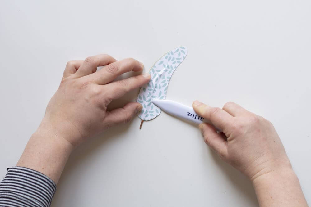 Bastelanleitung Do it yourself-Papierfedern. Schritt 6: Mit Falzbein Federschaft auf dem Papier nachfahren.