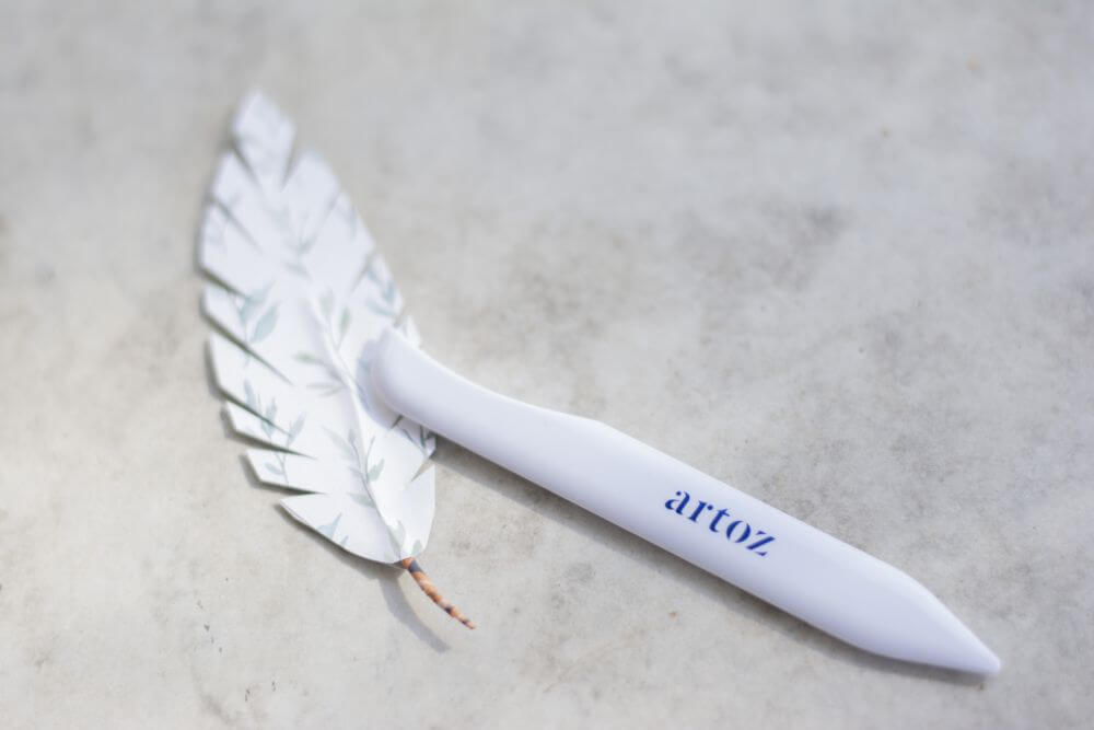 Nahaufnahme einer Do it yourself-Papierfeder und eines Falzbeins von Artoz.