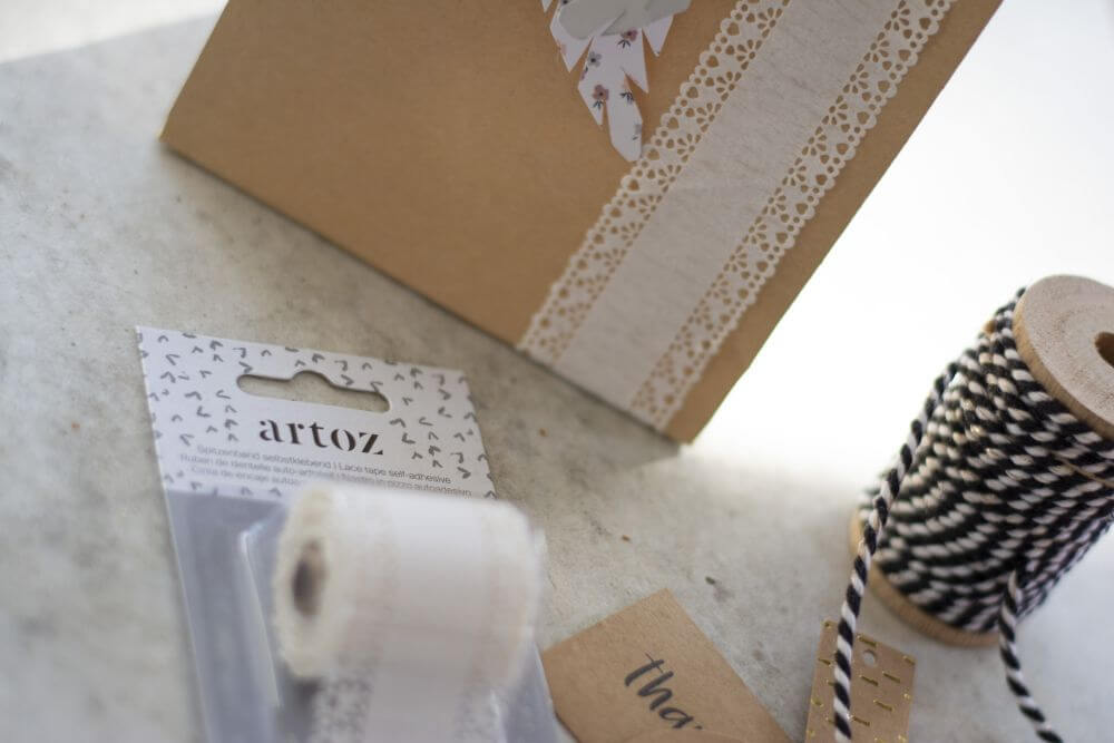 Nahaufnahme einer Geschenktüte, die mit Spitzentape von Artoz verziert ist.