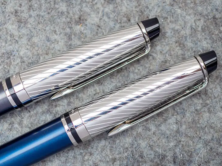 Die oberen Hälften zweier luxuriöser Waterman-Füllfederhalter ragen von unten links nach oben schräg ins Bild. Die Kappen sind aus edlem, graviertem Silber. Foto: Johanna Rundel