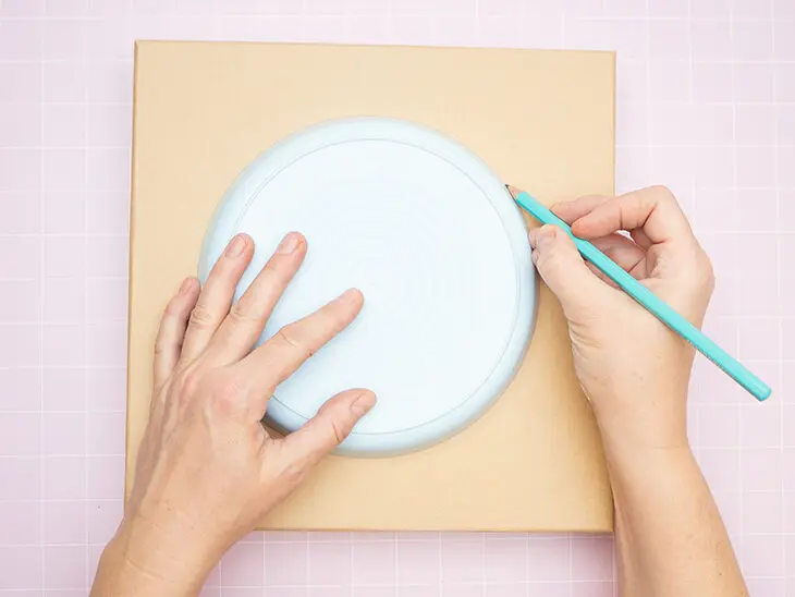 Jemand zeichnet mit einem Bleistift den Umriss eines Kuchentellers auf den Deckel einer Pappschachtel von KNORR prandell. Foto: Johanna Rundel