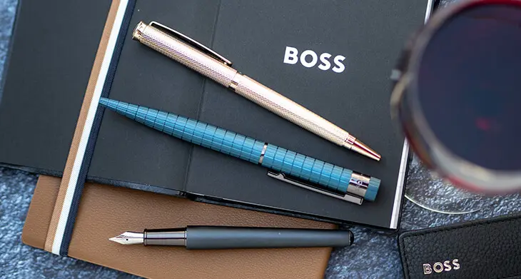 Drei Schreibwerkzeuge von HUGO BOSS liegen auf einem Schreibtisch. Foto: Johanna Rundel