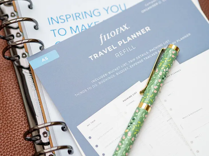 Eine Travelplanner-Einlage liegt auf einem braunen Filofax A5. Foto: Johanna Rundel