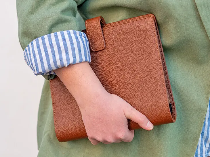 Jemand hat einen braunen Filofax A5 locker unter den Arm geklemmt. Foto: Johanna Rundel