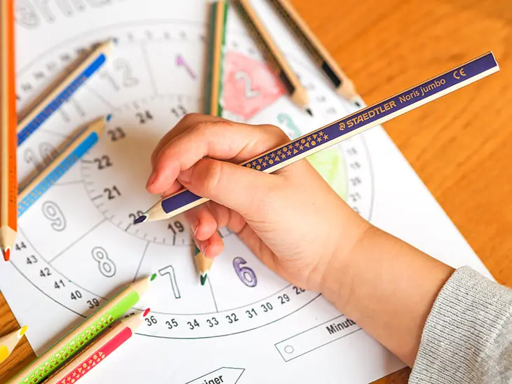 Ein Kind malt mit STAEDTLER Stiften eine Lernuhr aus. Foto: Johanna Rundel