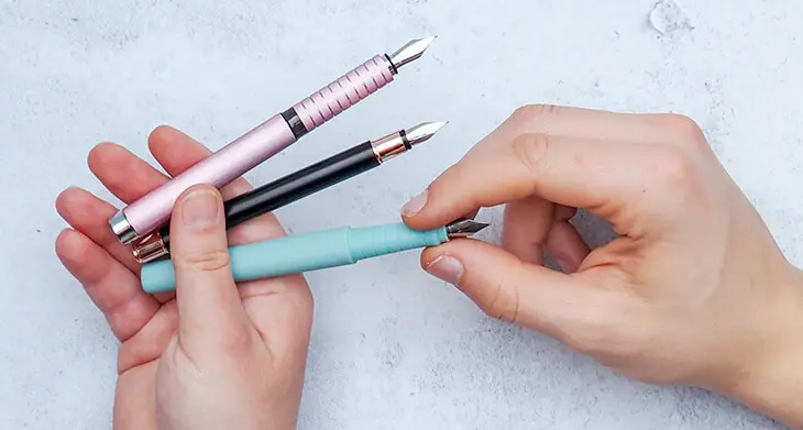 Jemand hält einer Person drei Füller von Faber-Castell zur Auswahl hin. Foto: Johanna Rundel