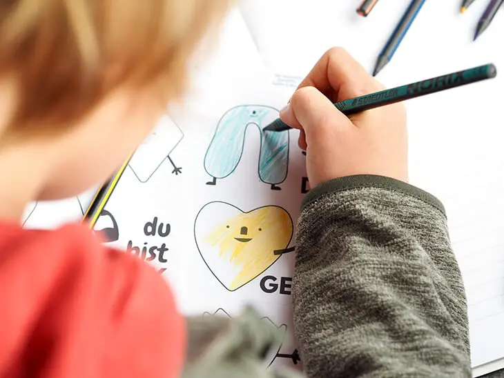 Ein Kind malt ein Mutmach-Sticker von Avery Zweckform aus. Foto: Johanna Rundel