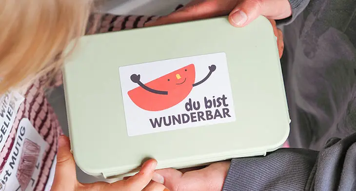 Übergabe einer Brotdose mit Mumach-Stickern von Avery Zweckform. Foto: Johanna Rundel