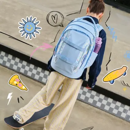 Ein Mädchen zieht an den Frontloops ihres bunten satch pack Rucksacks