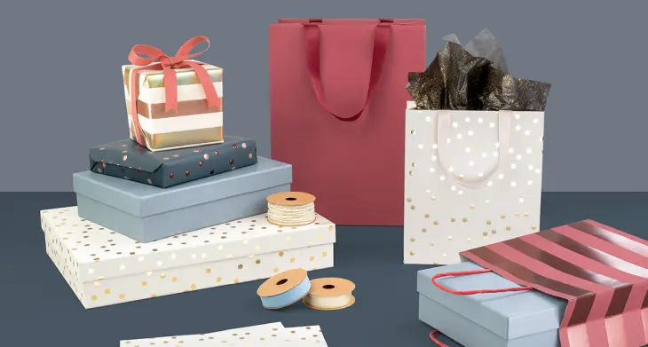 Geschenkpapiere, Kartonagen und Tüten von stewo liegen auf einem Tisch